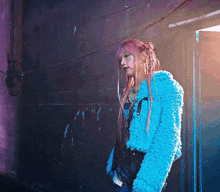 a woman with pink hair is wearing a blue fur jacket