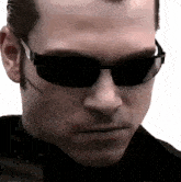 a man wearing sunglasses has a scar on his face