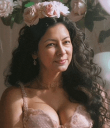 a woman wearing a pink bra and a flower crown on her head .