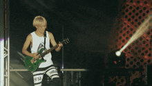 a man playing a guitar with the word hba on his shorts
