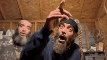 a man with a beard is making a funny face while standing next to another man