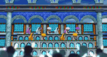 a group of people are sitting on a balcony watching a game .