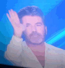 a man with a mustache is waving his hand in front of a blue background .