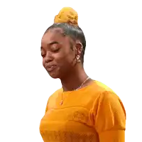 a woman wearing a yellow shirt and earrings looks down