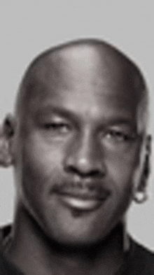 a close up of a man 's face with a bald head and a smile .