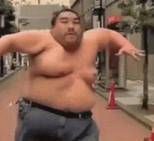 a shirtless man with a large belly is standing on a street .