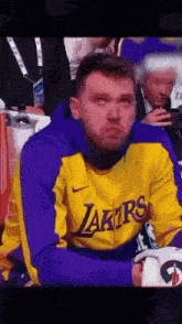a man wearing a yellow and purple lakers jacket