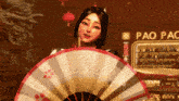 a woman holds a fan in front of a pao pac sign