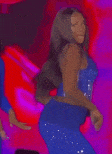 a woman in a blue corset and blue pants is dancing on a stage .