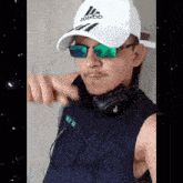 a man wearing headphones and a white hat with the word adidas on it