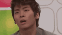 a young man is making a funny face with his mouth open .