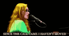 a woman singing into a microphone with the words since the call came i haven 't moved below her