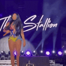 a woman in a bikini is dancing on a stage .