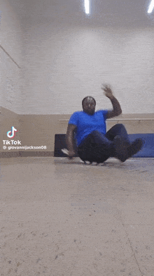 a man in a blue shirt is doing sit ups on the floor .