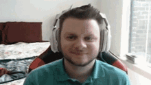 a man wearing headphones is sitting in a chair and smiling .