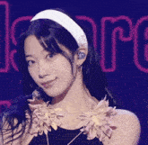 a close up of a woman wearing a headband and flowers on her neck