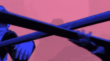 a person is holding two blue swords crossed over each other against a pink background .