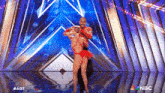 a man and a woman are dancing on a stage with nbc written on the bottom