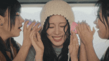 a girl wearing a knitted hat is surrounded by other girls