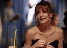 a woman in a strapless dress is holding a card that says ecg