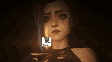 a woman with tears on her face is holding a candle and a sticker that says true