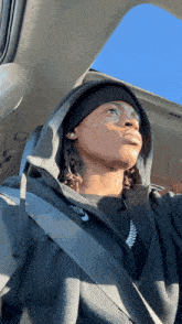a man wearing a black nike hoodie is looking out the window