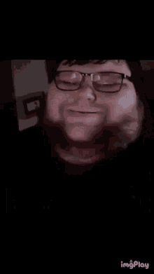 a close up of a man with glasses and a beard .