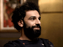 a man with curly hair and a beard is wearing a black nike shirt