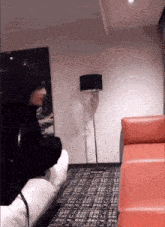a person sitting on a couch in a room with a lamp