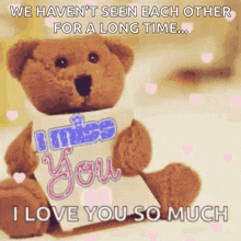 a teddy bear is holding a sign that says i miss you