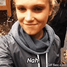 a woman taking a selfie with the words " nah " on her shirt