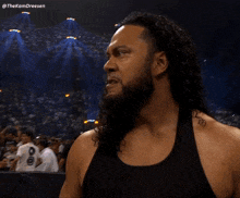 a man with long curly hair and a beard is wearing a black tank top with the hashtag thekamdreesen on the bottom