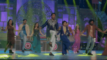 a group of people are dancing on a stage in front of a sign that has the letter c on it