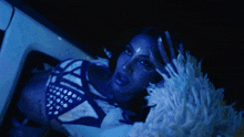 a woman in a blue and white outfit is looking out of a window
