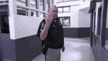 a police officer giving the middle finger while walking down a hallway