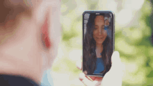 a person is taking a picture of a woman on their phone