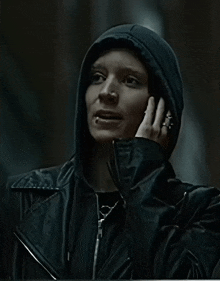 a woman wearing a hooded jacket is talking on her phone