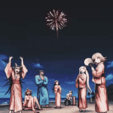 a group of people are standing on a beach watching fireworks