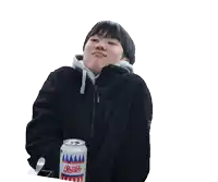 a young man in a black jacket is holding a can of soda and making a funny face