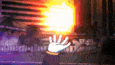 a person 's hand is holding a flame in front of a building