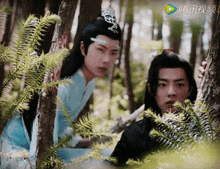 two men are standing in a forest with chinese writing on the screen