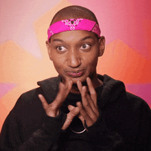 a man wearing a pink bandana on his head making a funny face