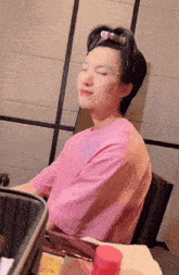 a person wearing a pink shirt with a face mask on their face