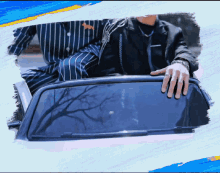 a man in a striped shirt is sitting in the back of a car