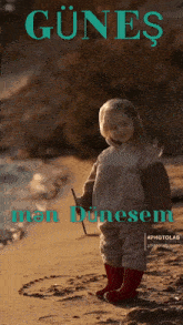 a little girl standing on a beach with the words günes men dunesem