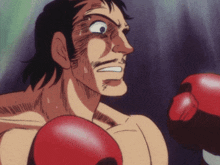 a man wearing red boxing gloves is sweating and making a funny face