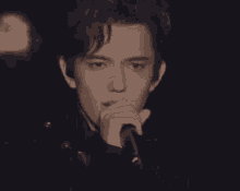 a close up of a man holding a microphone and smiling .