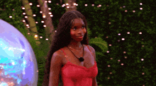 a woman in a red dress is standing in front of a balloon