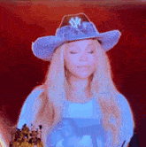 a woman wearing a cowboy hat with a ny on it