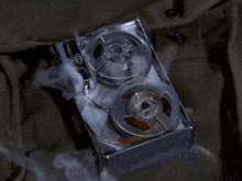 a tape recorder with smoke coming out of it is sitting on a table .